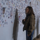 Hero standing before a wall where people are trying to find their now-dead loved ones.